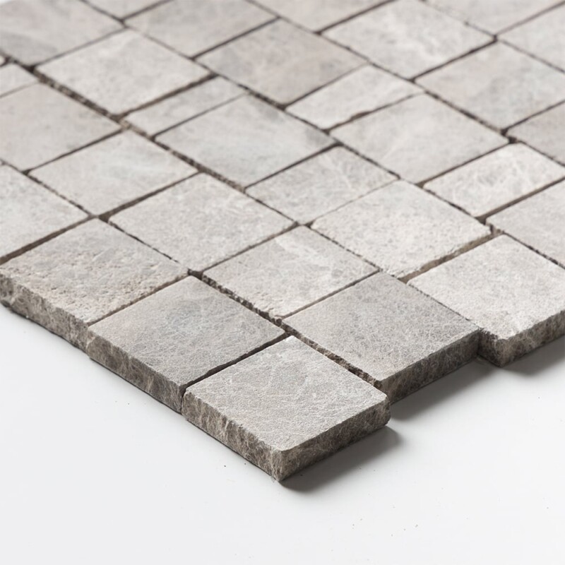 Angled perspective of Maroon Di Notte Leather Scarpa Rough Cut Marble Mosaic tile, capturing the irregular hand-clipped edges and staggered joint pattern that give the surface its dimensional, rough-cut texture.