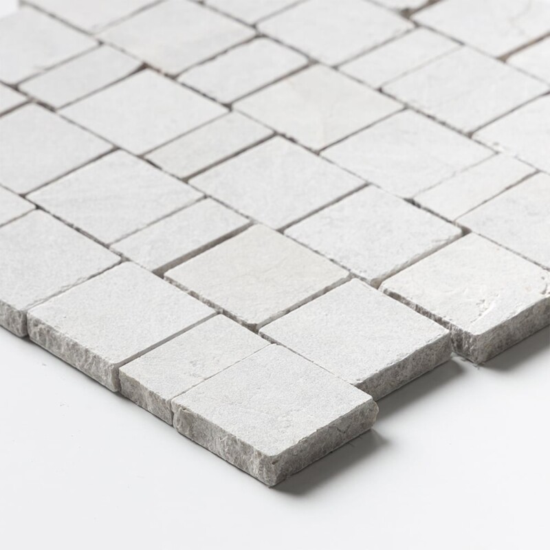 Angled perspective of Silver Shadow Leather Scarpa Rough Cut Marble Mosaic tile, capturing the irregular hand-clipped edges and staggered joint pattern that give the surface its dimensional, rough-cut texture.