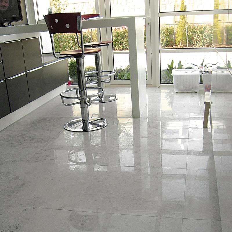 Modern living space with grey polished marble flooring and natural daylight ambiance by Country Floors