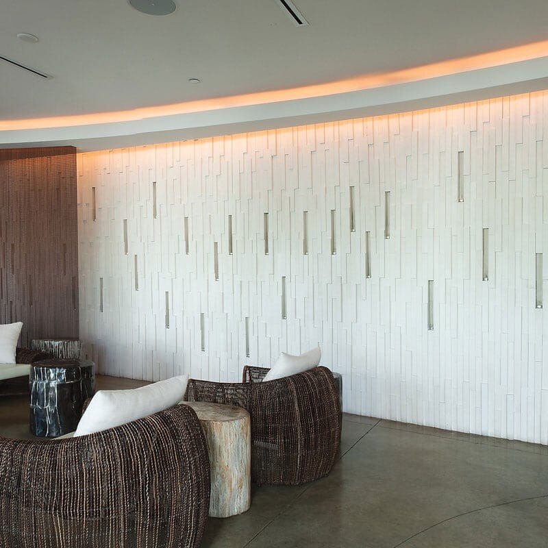 Linear limestone mosaic feature wall in contemporary lounge by Country Floors