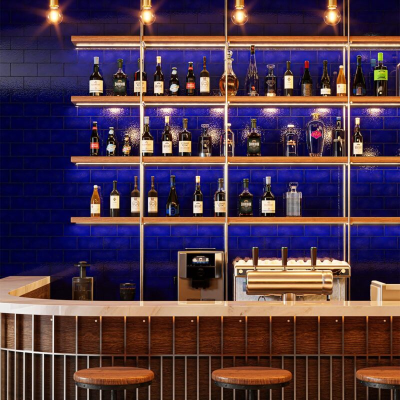 Glossy blue terracotta tile installed as a bold bar backsplash by Country Floors