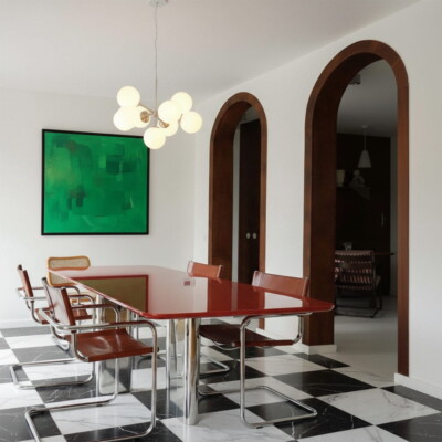 Elegante sala da pranzo con pavimento in marmo a scacchiera e dettagli di arte moderna di Country Floors.