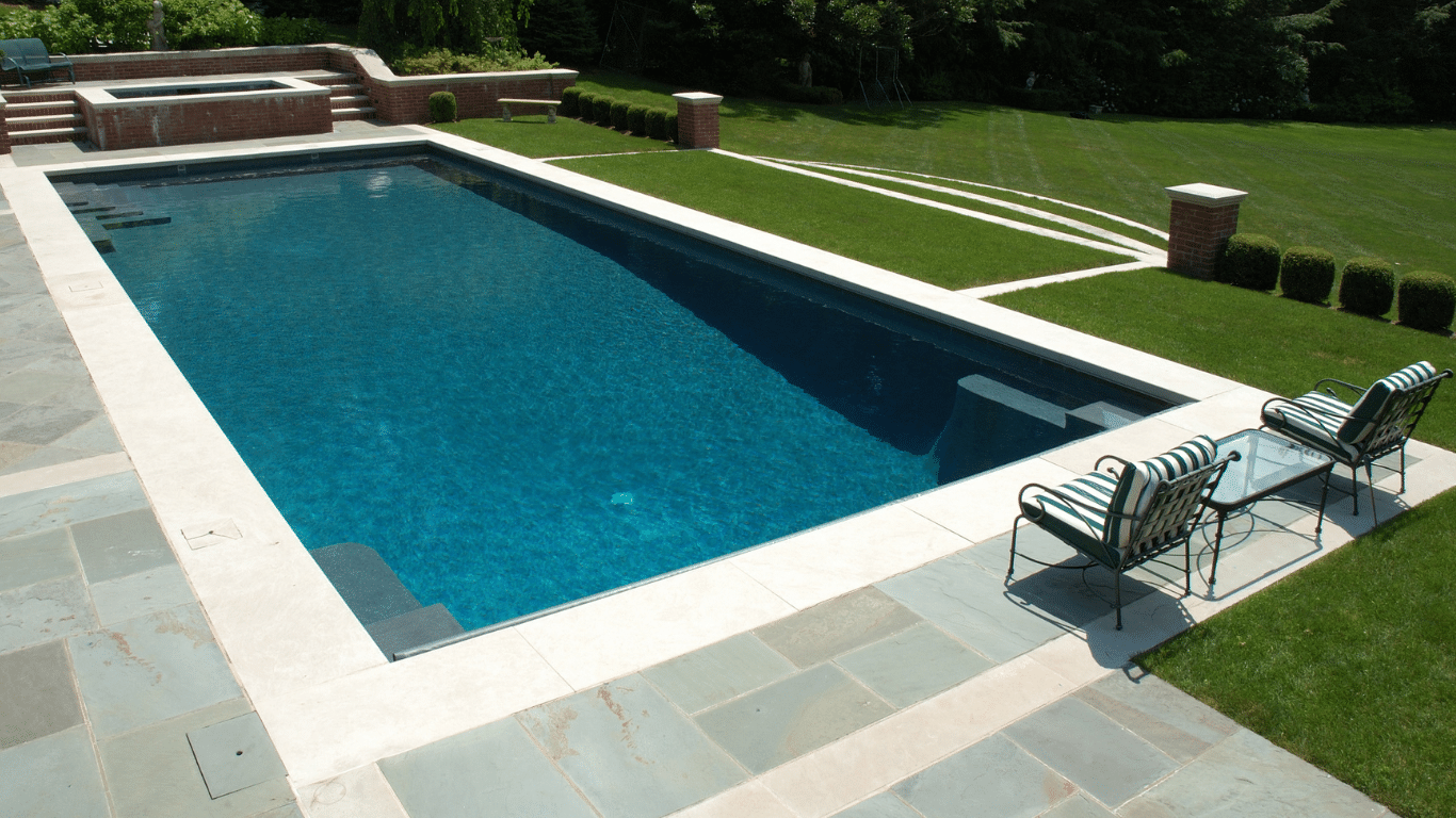 Pool with blue tiles and two chairs