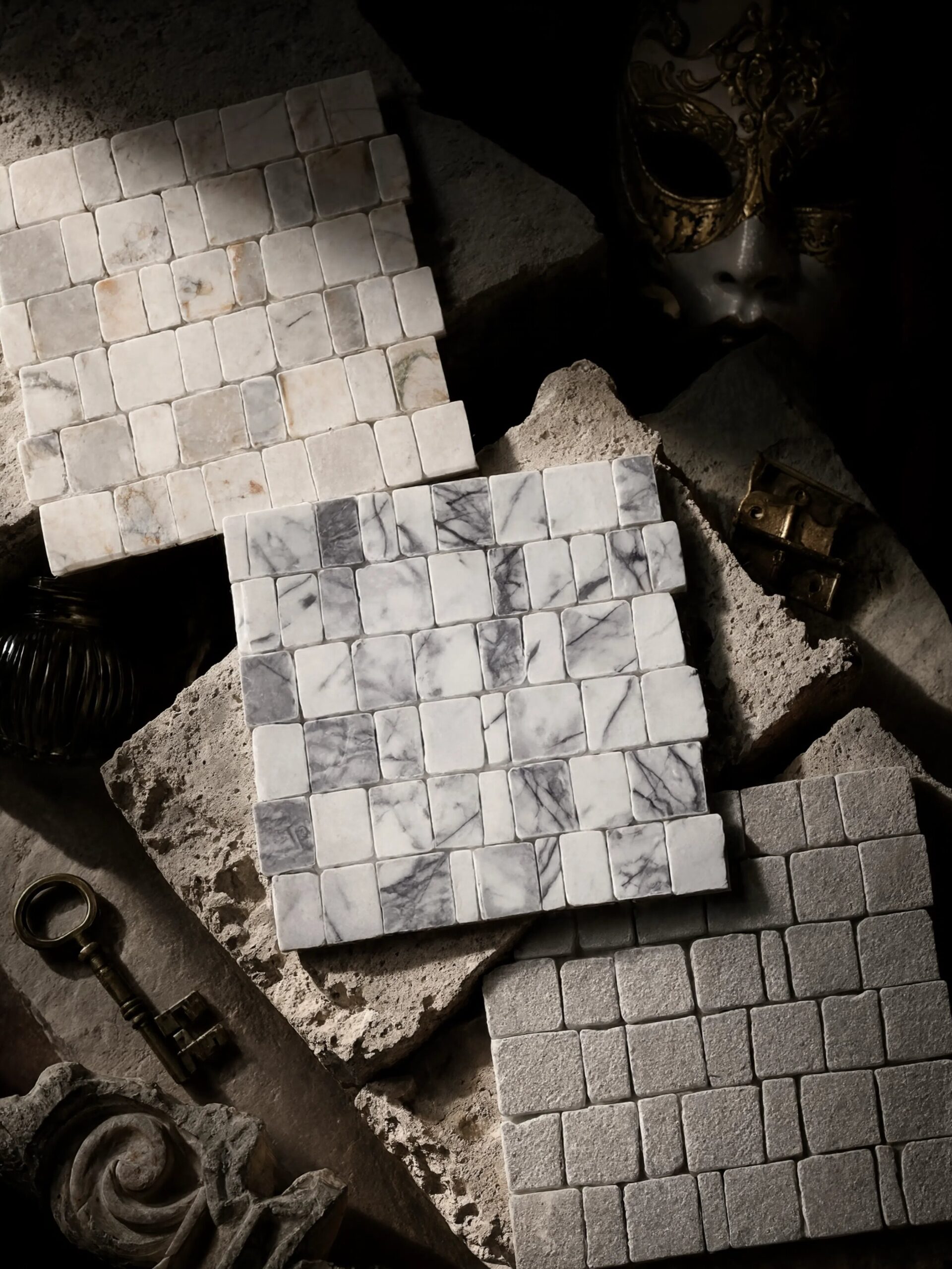 Scarpa Mosaics white and grey marble mosaic sheets styled with a vintage brass key and hardware, evoking the historic Venetian craftsmanship behind the collection.