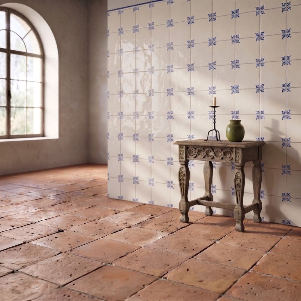 Handmade terracotta floor and blue hand-painted tile stair risers on a covered Mediterranean style patio.
